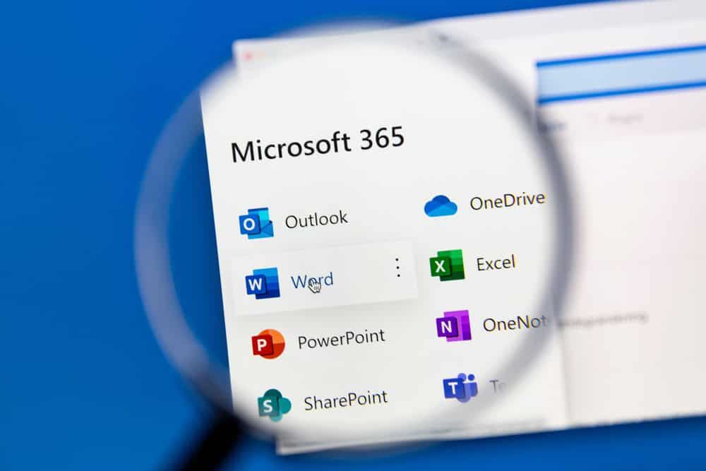 A magnifying glass focuses on a computer screen displaying Microsoft 365 applications. Icons for Outlook, OneDrive, Word, Excel, PowerPoint, OneNote, and Teams are visible. The background is a blurred blue.