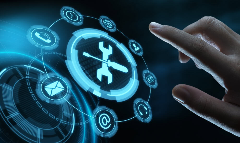 A hand reaches toward a holographic interface with a central wrench and screwdriver icon, symbolizing IT support. Surrounding icons include a lock, envelope, people, at symbol, and bar graph, representing various digital functions or services.